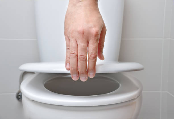 hand of a man closing the lid of a toilet-Protein Shakes Make You Poop